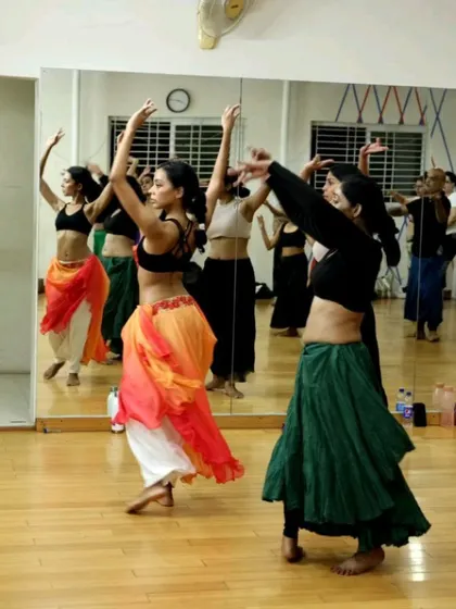 The joy of movement is evident as students learn a group choreography during the Indian Fusion Weekender. The class combines technical skill with expressive performance.