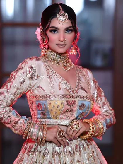 A modern bridal look with a pastel multi-color lehenga. The makeup is kept nude and glowy with a pop of glitter on the eyes.