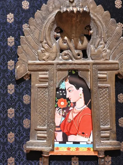 A close-up of the Mughal miniature Prabhavali. The artwork, a digital print on archival paper, is nestled within the intricate brass frame, creating a window into another time.