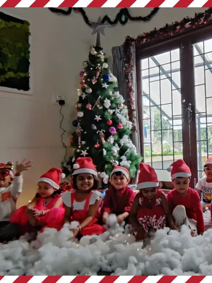 The whole class poses for a group photo in their Santa hats, surrounded by "snow."