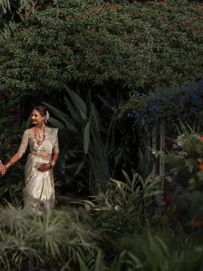 Walking together through a beautiful, blooming garden. The vibrant colors of the flowers and greenery add a lively and romantic feel to this couple portrait.