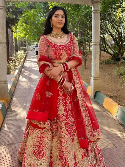 Radiating elegance in a classic red lehenga. For this North Indian bridal style, I created a sophisticated look with soft, flowing hair and makeup that highlighted her features, ensuring she looked and felt like royalty on her big day.
