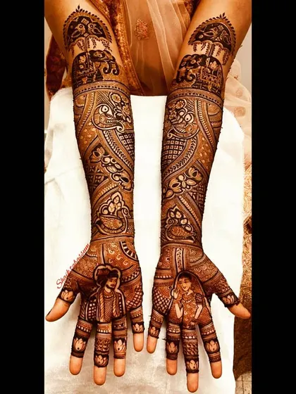 This design features charming, stylized portraits of the bride and groom on the palms, with traditional elephant processions detailed on the forearms.