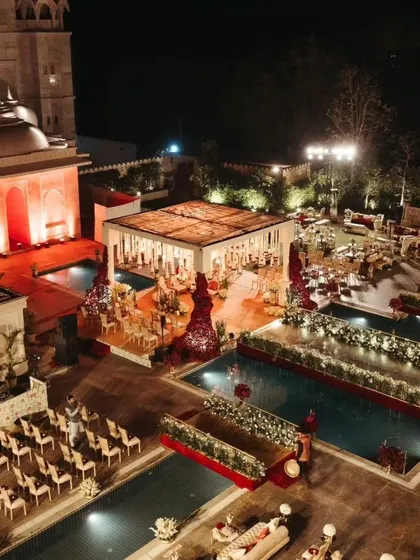 An aerial shot of the entire wedding setup, showing the mandap, guest seating, and the stunning poolside location.