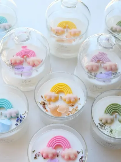 These rainbow-themed candles in a cloche jar are a whimsical and joyful choice for a baby shower.
