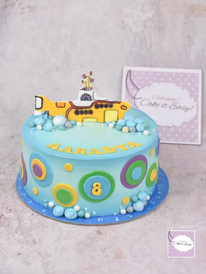 The main cake for the Beatles-themed party, featuring the Yellow Submarine and colourful, retro circles.