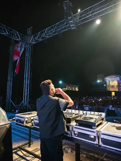 On the mic, hyping up the crowd at a large outdoor concert. It's crucial for me to connect with the audience directly.