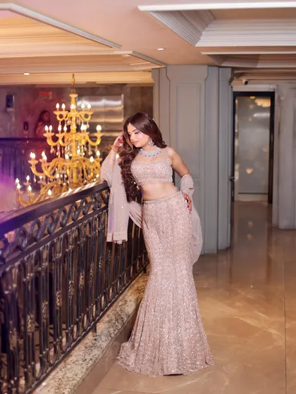 A full-length shot that captures the elegance of the mermaid gown and the grandeur of the venue's chandelier. I focus on composition to ensure both the outfit and the setting shine.
