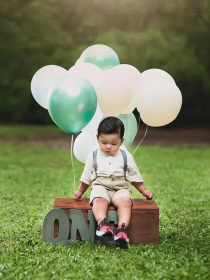 A dreamy outdoor first birthday shoot. This little boy looks so peaceful with his balloons, celebrating his big day in nature.
