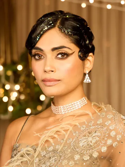 A close-up of the vintage finger wave hairstyle. The glitter adds a fun, celebratory element perfect for a cocktail party or sangeet.