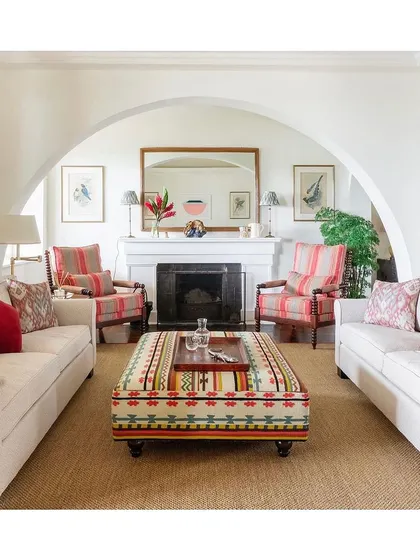 This gorgeous drawing room is a celebration of patterns and colours. It's a perfect example of how soft furnishings, from the striped armchairs to the patterned ottoman, can absolutely transform a neutral space.