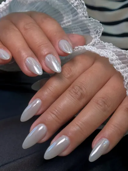 The almond shape of the nails enhances the elegance of the classic chrome polish, creating long, graceful lines.
