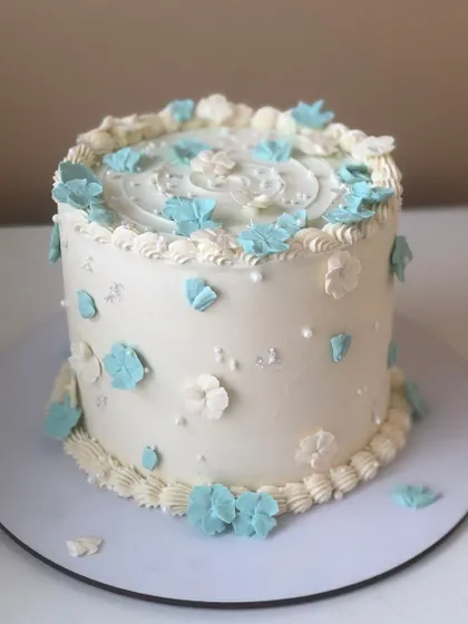 A dainty cake with delicate blue and white flowers.