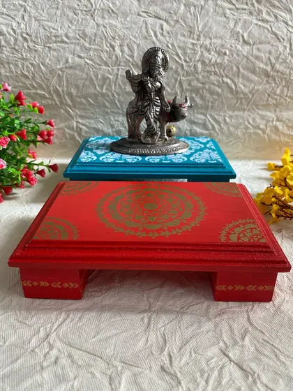 A red mandala chowki and a teal damask chowki, shown with a Krishna idol. The vibrant colors are perfect for festive seasons.