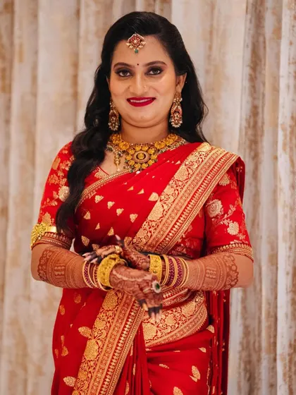 This client chose a classic red Banarasi saree for a family function. I designed a matching blouse with delicate gold embroidery to enhance the richness of the fabric.