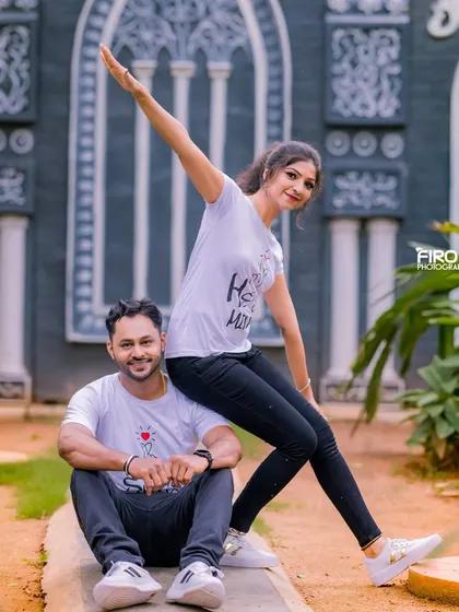 A fun and energetic pose with the couple in matching t-shirts. This shot is full of personality and shows off their playful dynamic.