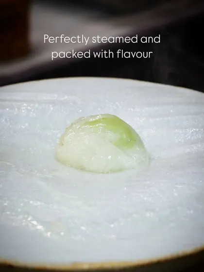 A single, perfectly steamed Indonesian Truffle Edamame Dimsum. The delicate wrapper encases a creamy and flavorful edamame filling, creating a melt-in-your-mouth experience.