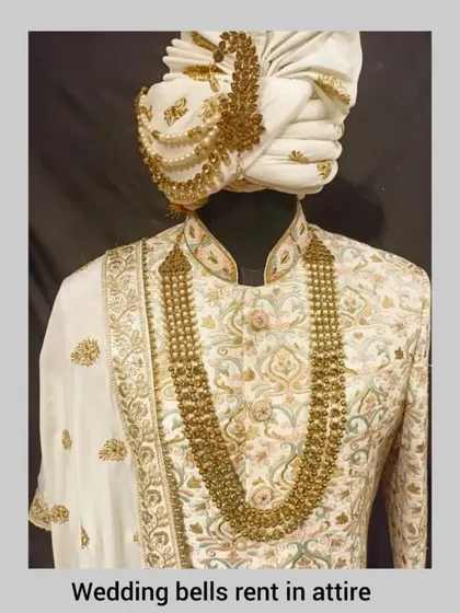 A close-up of our classic ivory sherwani, showcasing the intricate gold embroidery and the matching pagri.