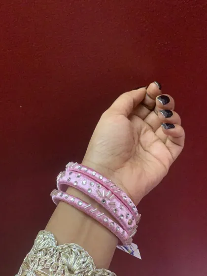 A simple yet sparkling pair of pink silk thread bangles with a line of delicate crystals. Perfect for adding a touch of glamour.