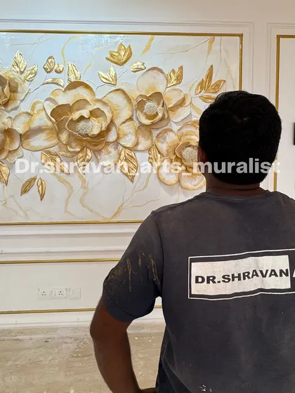 You feel the fire in you when you stand in front of what you created! This is me admiring a finished floral relief mural with beautiful gold accents on a marble-textured background.