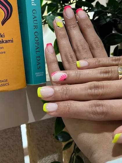 Nails that make hearts flutter! This neon French manicure with abstract floral details is a bold and playful summer look.