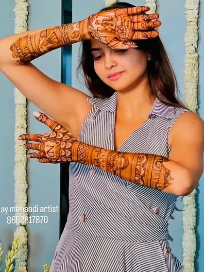 A creative pose showing off the intricate details of the full-arm mehndi design.