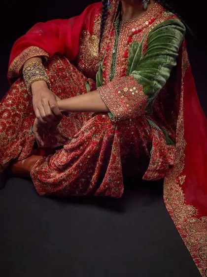 A detailed shot focusing on the lower half of a Debyani & Co outfit, highlighting the intricate embroidery on the pants and sleeves.