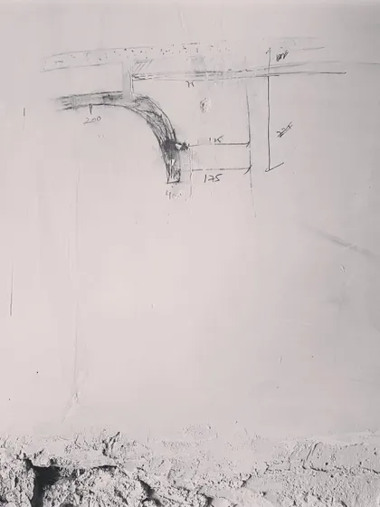A quick sketch made directly on the wall at a construction site. This is how we often communicate complex details like curves to the team, ensuring the vision is translated accurately.