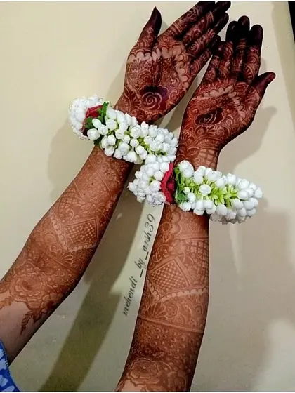 Another view of the beautiful dark stain, adorned with floral gajra bracelets for a festive look.