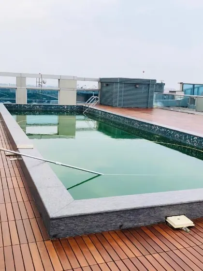 This rooftop installation showcases the beauty and functionality of IPE wood decking surrounding a pool. The wood's natural oils make it weather resistant, perfect for exposed urban environments.