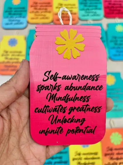 The pink version of the custom-messaged hanging, perfect for adding a pop of color and inspiration to an office desk.