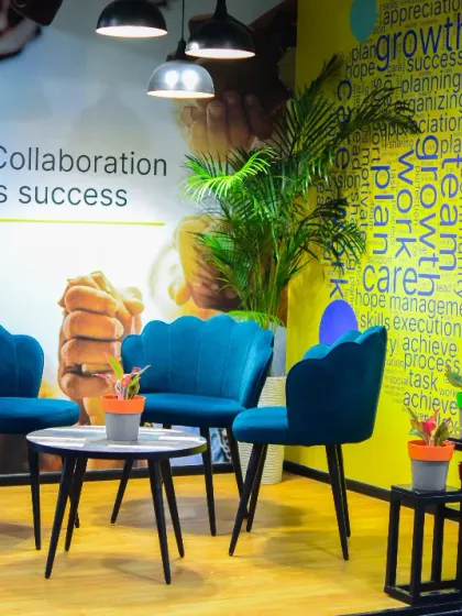 We created this cozy breakout area to show how plants can make collaborative spaces more inviting. The combination of a large Areca Palm and smaller potted plants on tiered stands adds texture and life, turning a simple seating arrangement into a refreshing retreat.