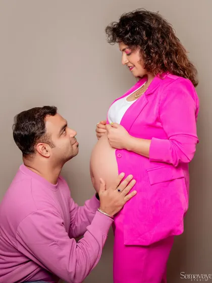 A sweet and adoring moment as the father-to-be looks up at his partner and their baby bump. A modern take on a classic pose.