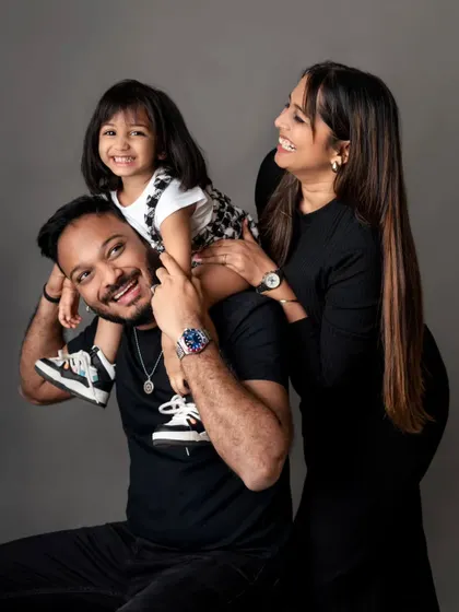 A happy family portrait with the daughter on her father's shoulders, showcasing a classic and joyful pose.