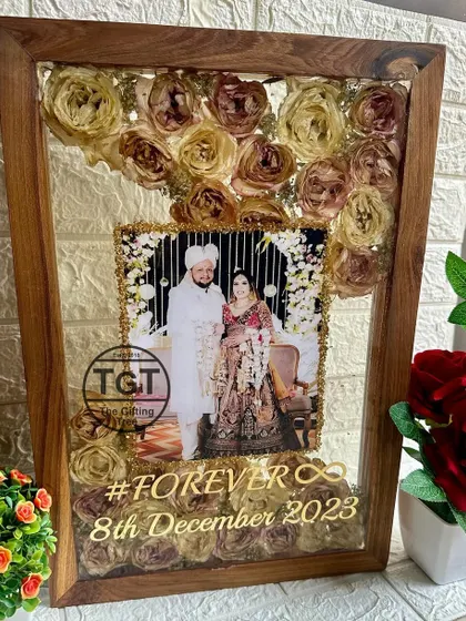 The golden text hashtag #FOREVER and the wedding date are elegantly placed over the preserved flowers, adding a modern, personal touch.