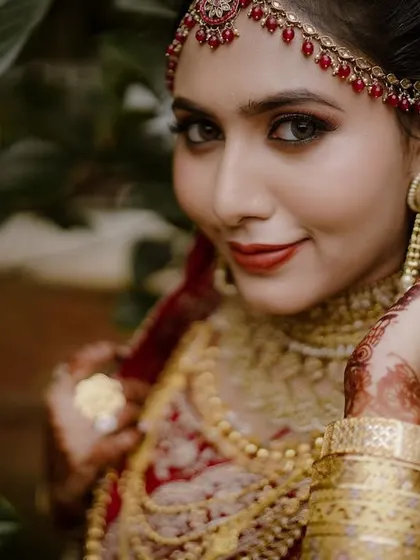 A close-up of the bride, her confident gaze and beautiful smile perfectly complementing her elaborate wedding attire.