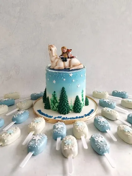 A heartwarming cake inspired by the book "The Boy, the Mole, the Fox and the Horse," complete with a wintery scene and matching cakesicles.