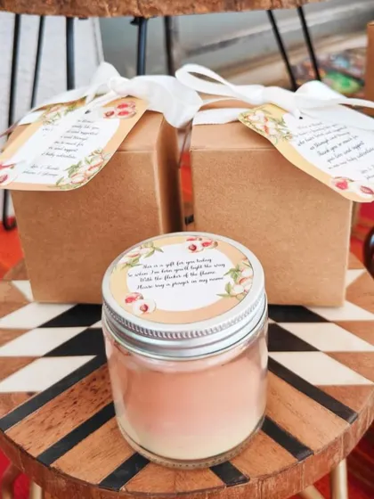 A single peach-themed baby shower favor, showing the custom candle and matching gift box.