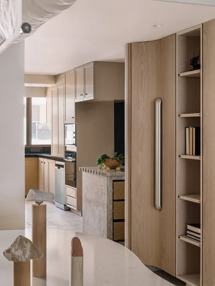 The kitchen at Kanso House is designed for the realities of Mumbai living, with a spacious layout and a unique kitchen library nook. The view extends from the dining area through to the kitchen, creating an open, connected feel that is both functional and beautiful.
