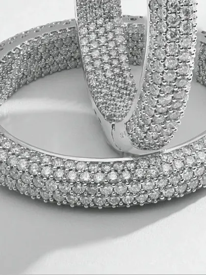 This macro photograph captures the intricate detail of pavé-set diamond hoop earrings. Every single diamond is in sharp focus, demonstrating the precision required for high-end e-commerce imagery where texture and quality are paramount.