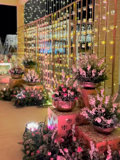 A floral entryway for a traditional reception, where contemporary lighting and metallic textures are blended with classic pink florals.