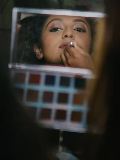 A creative shot through the mirror, capturing the moment I apply lipstick. These are the final, transformative touches.
