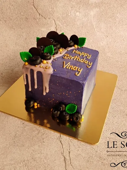 This purple cube cake is one of my favorite modern designs. It's a half-kg Lemon Blueberry Cream Cheese cake with a sharp, square shape, a delicate drip, and fresh blueberry decorations.