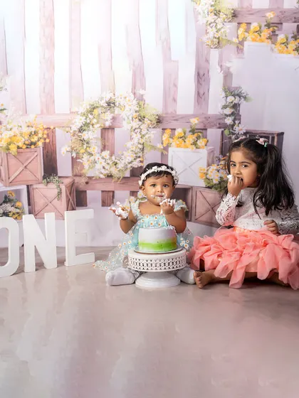 A big sister joins in on the cake smash fun! Capturing sibling interactions during milestone shoots makes the memories even more special and heartwarming.