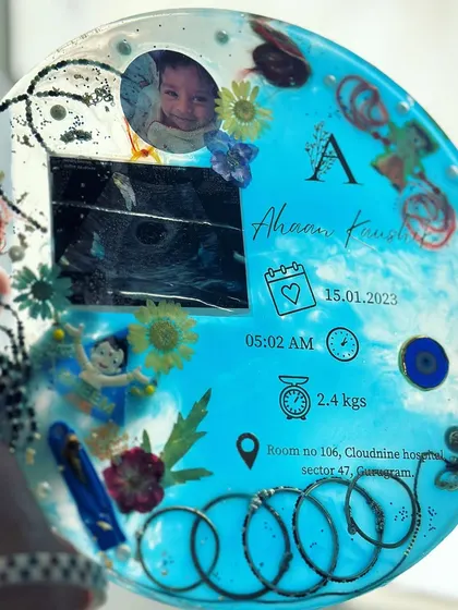 A closer look at the baby details frame, showing the ultrasound, photo, and all the little mementos that tell the story of baby Ahaan's birth. The light blue theme is perfect for celebrating a baby boy.