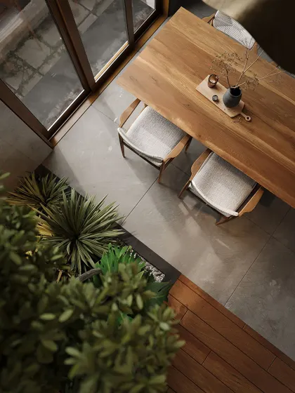 Another top-down perspective of the dining table and indoor planter, showcasing the material palette of wood, concrete, and greenery.