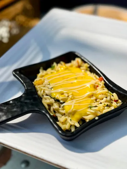 A close-up of the Orzo pasta dish, showcasing the creamy texture of the Thai pumpkin sauce and the perfectly cooked pasta.