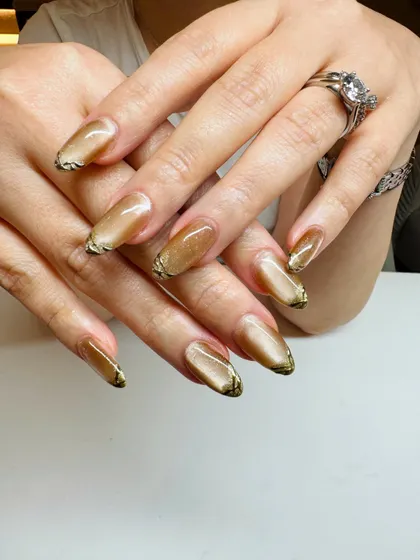 A closer look at the liquid-gold effect of this cat-eye manicure, accented with a touch of black at the tips for extra definition.