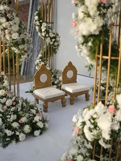 The intimate seating arrangement within a floral mandap, showing how we focus on every detail to make the couple's space feel special.