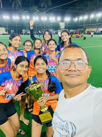 A proud coach takes a selfie with the winning women's team and their championship trophy. These are the moments we work so hard for.